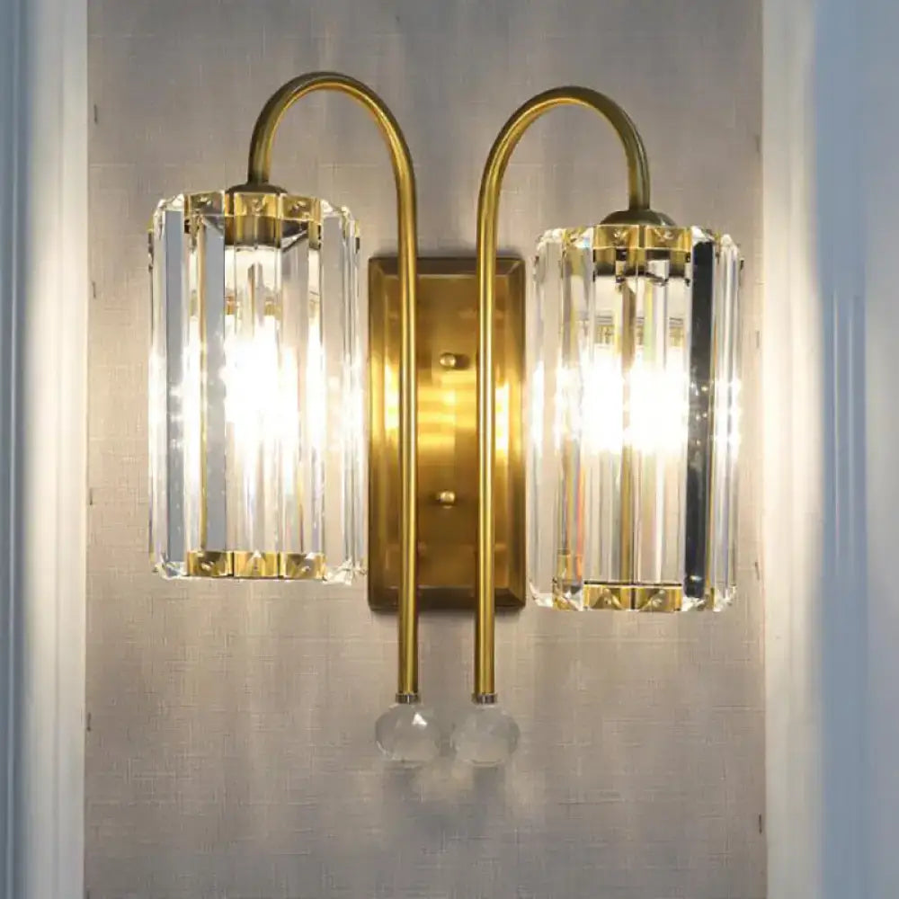 Brass-finished vintage gold wall light with two clear crystal shades and dangling glass orbs for bedroom use