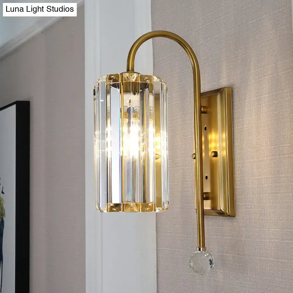 Vintage gold wall light with a sleek curved arm and clear crystal shade featuring vertical crystal panels