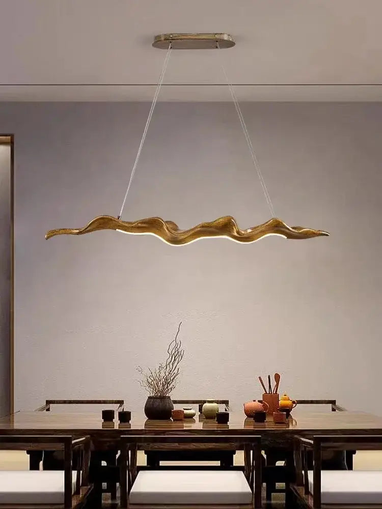 Golden vintage character pendant light with sculptural wave-like design and iron finish for dining room use