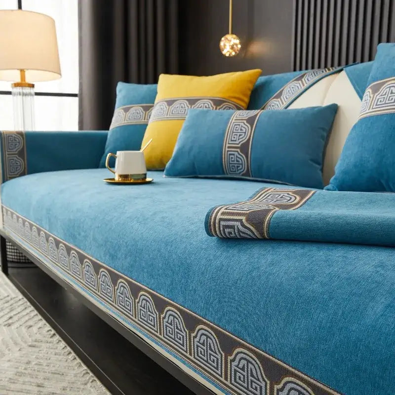 Blue velvet sofa cover with intricate dark gray and cream geometric embroidery edges for vintage living room decor