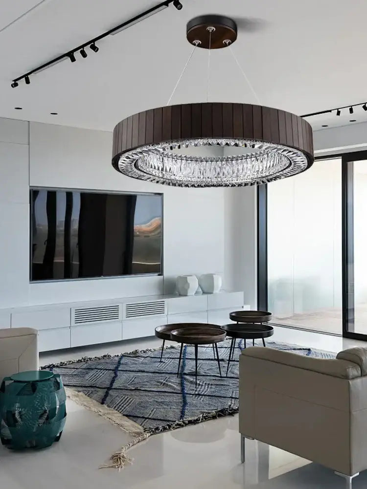 A modern gray glass large ceiling pendant light with a dark wood frame and sparkling crystal elements for stairwell