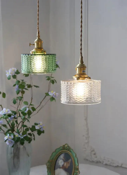 Two vintage glass shade chandelier pendant lights with green and clear textured glass shades and brass fixtures hanging from cords