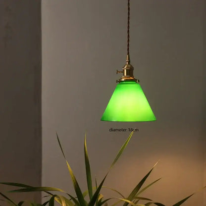 Vintage pendant lamp featuring a green glass shade brass hardware and braided cord ideal for kitchen lighting