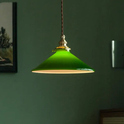 Vintage green glass pendant lamp with brass hardware and braided cord featuring a vibrant enamel pendant lamp design