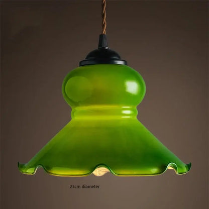 Vintage green glass pendant lamp with scalloped edge and black metal top for kitchen lighting with brass hardware