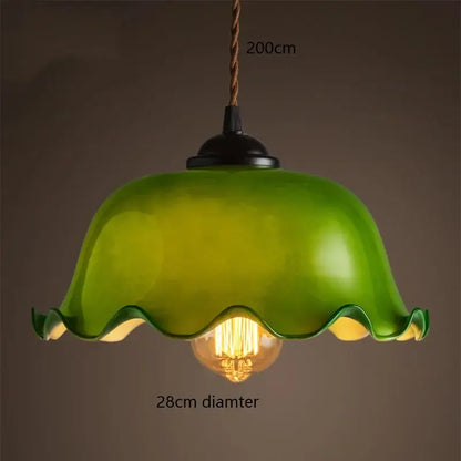 Vintage green glass pendant lamp with wavy edges and brass hardware featuring a warm edison vintage pendant glow