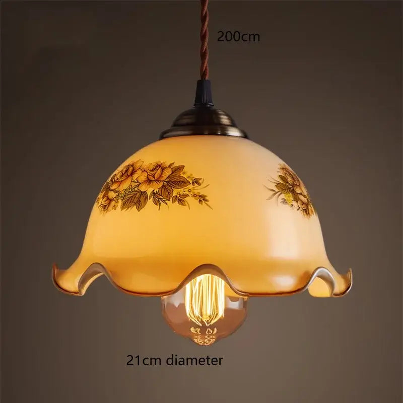 Warm amber glass vintage pendant lamp with delicate floral patterns and scalloped edge for kitchen use brass hardware