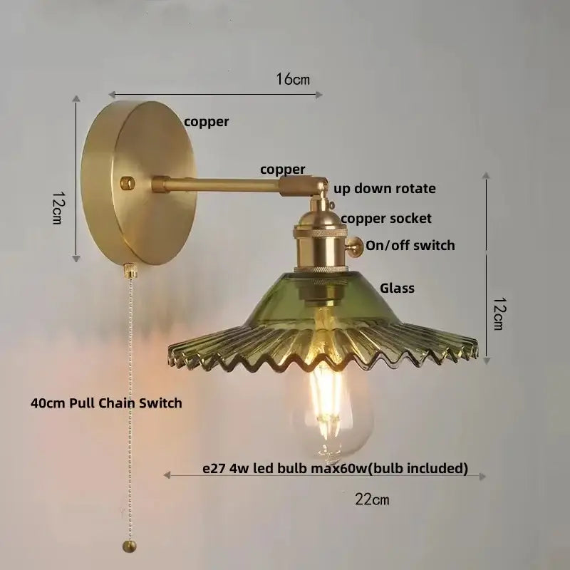Vintage green glass wall light with brass sconce and pull chain switch featuring a fluted shade and exposed edison bulb