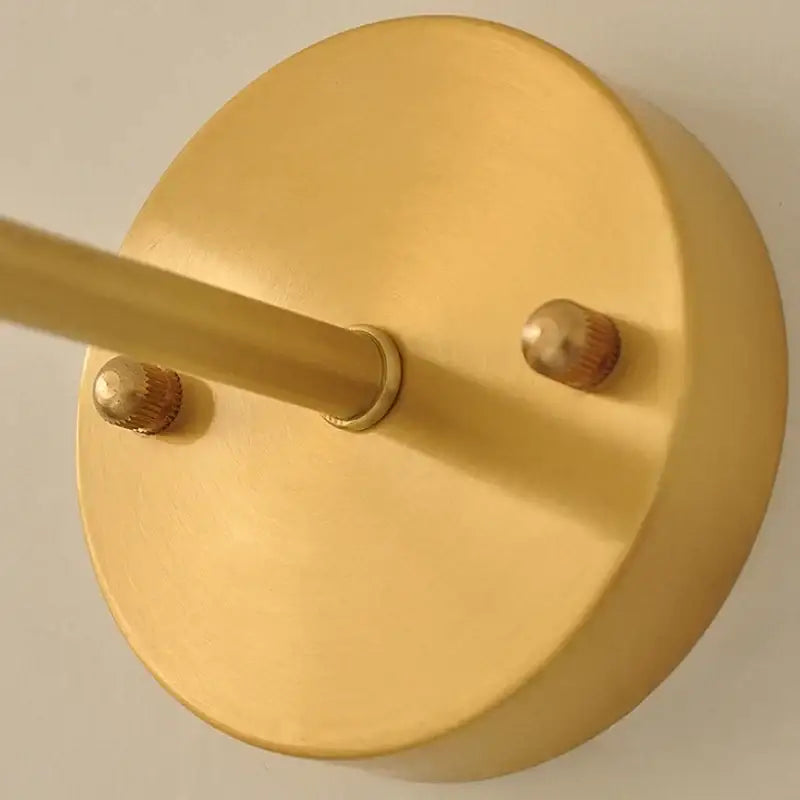 Vintage green glass wall light with pull chain switch featuring gold-finished circular metal fixture and decorative knobs