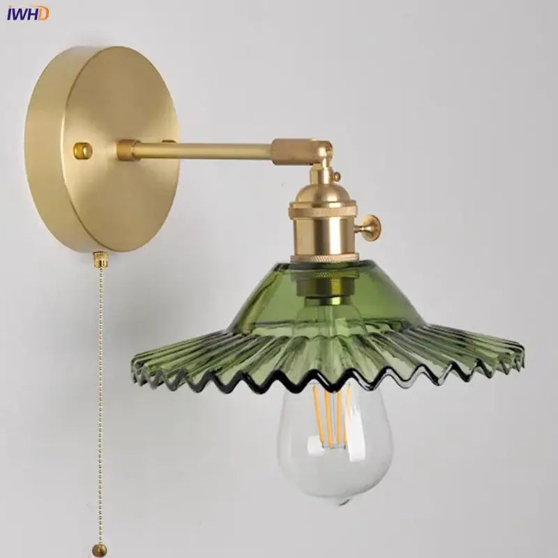 Vintage green glass wall light with brass arm and scalloped olive glass shade featuring pull chain switch wall light