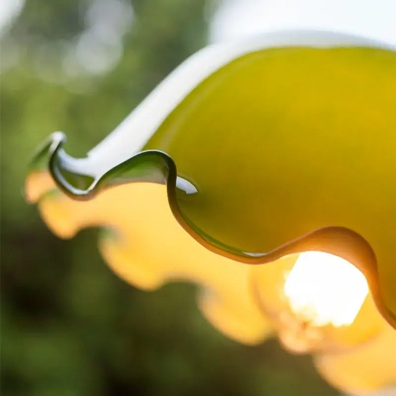 Vintage green lotus led pendant light featuring a translucent yellow glass lampshade with smooth wavy edges