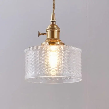 A clear glass led pendant lamp with a textured chevron pattern and brass hardware for dining room lighting