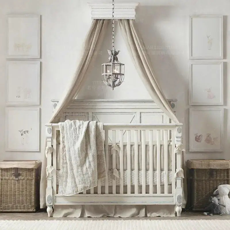 White wooden crib with ornate carvings and draped beige canopy beside decorbites grey metal cage lantern chandelier dining room leaf motif