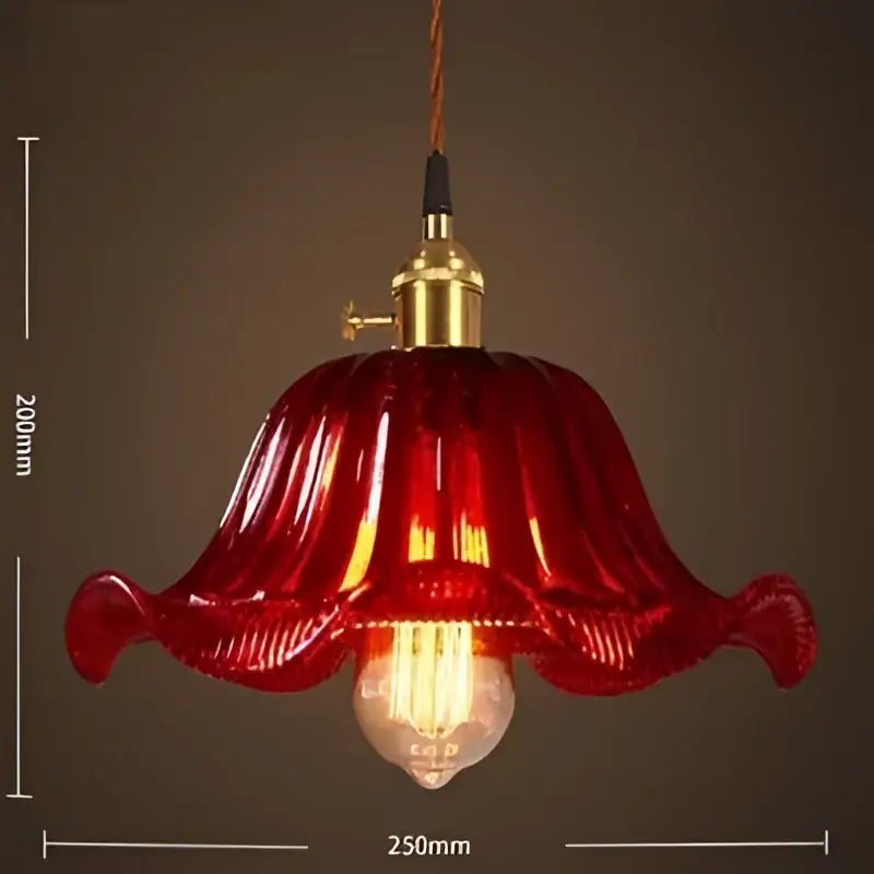 A vibrant red petal-shaped glass pendant light with brass fixture and exposed bulb for vintage living room pendant lights