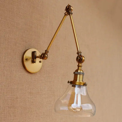 Vintage industrial brass glass ball swing arm light bedroom sconce featuring a brass adjustable wall sconce with clear glass shade and exposed filament bulb