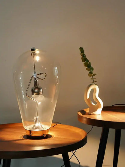 Vintage industrial glass desk lamp with clear bulbous enclosure and exposed metallic filament by decorbites glass desk