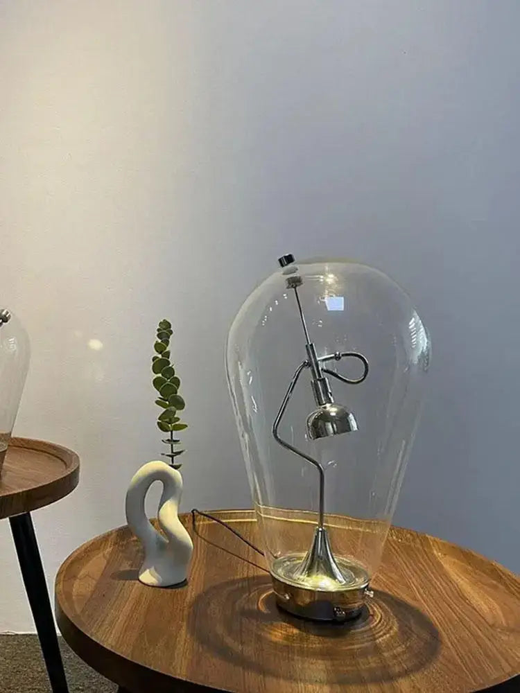 A vintage industrial decorbites glass desk lamp with a transparent dome and metallic curved arm base for bedroom decor