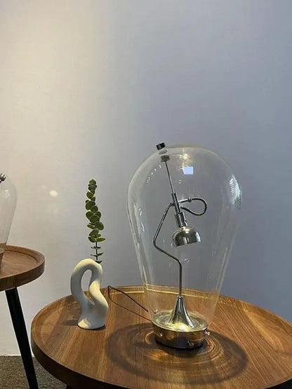 A vintage industrial decorbites glass desk lamp with a transparent dome and metallic curved arm base for bedroom decor