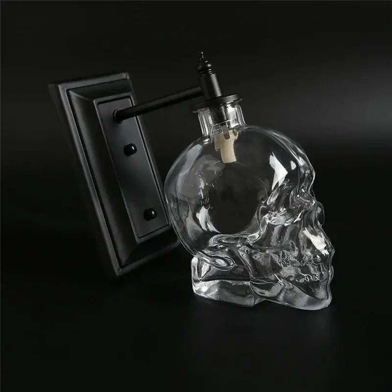 Vintage industrial glass skull wall sconce with clear glass skull bottle, black metal fixture, and white cork stopper