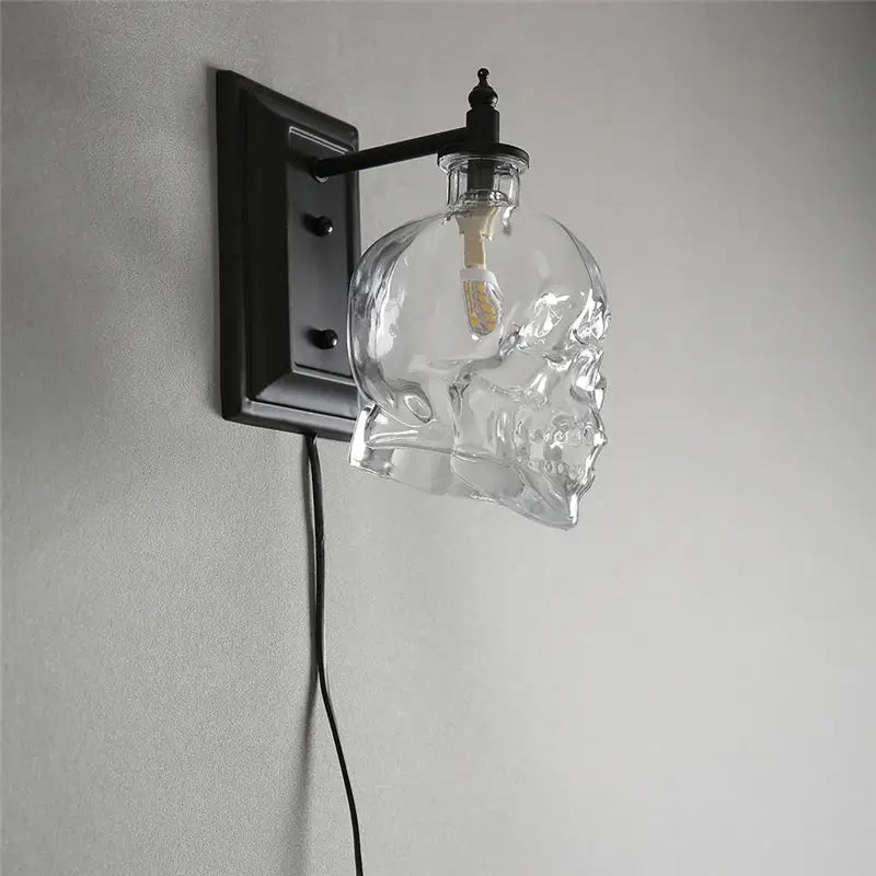 Clear glass skull wall sconce with black metal bracket and arm for vintage industrial living room lighting