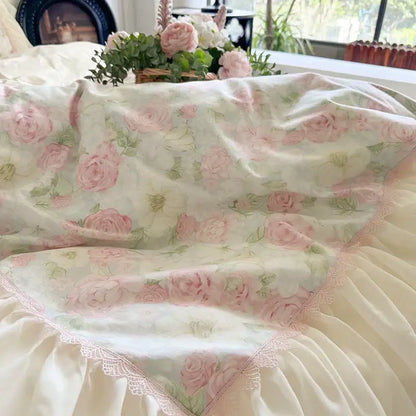 A cream cream-colored bedding set with soft pink roses green foliage and lace-trimmed decorbites french lace ruffles