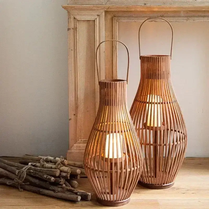 Two tall slender vintage natural bamboo lantern candle holders with warm wood slats and metal handles for living room decor