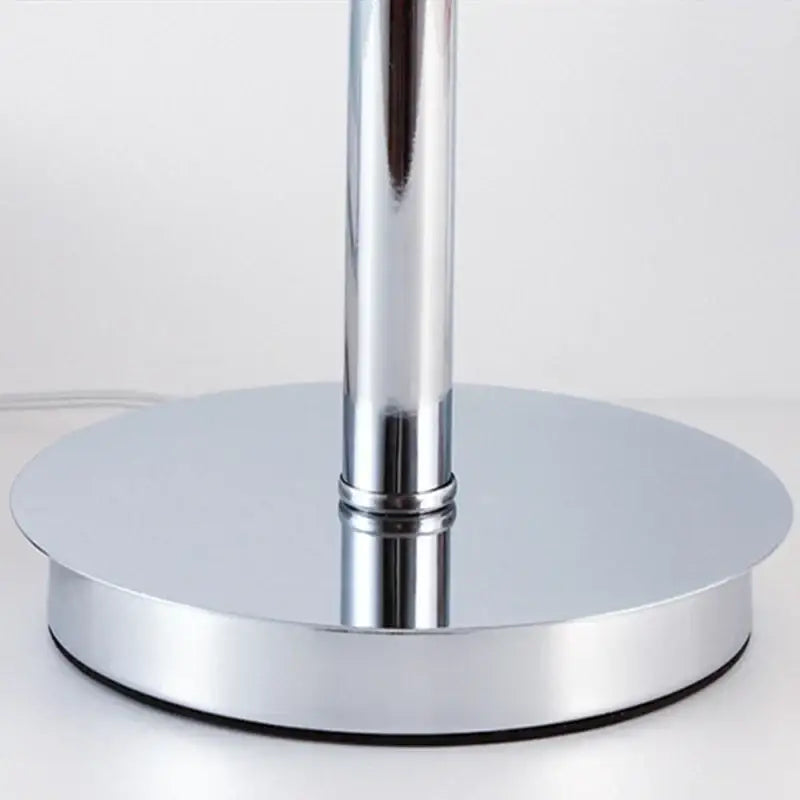 Vintage table lamp with chrome finished cylindrical stem and circular platform base for bedroom lighting