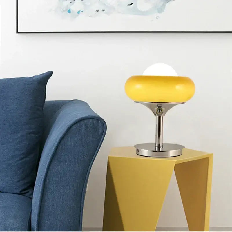 A vintage table lamp with a vibrant yellow glass shade and polished chrome base for bedroom lighting