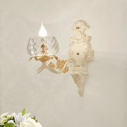 Elegant vintage ornate cream and gold wall light sconce with faceted crystal glass shade for bedroom lighting