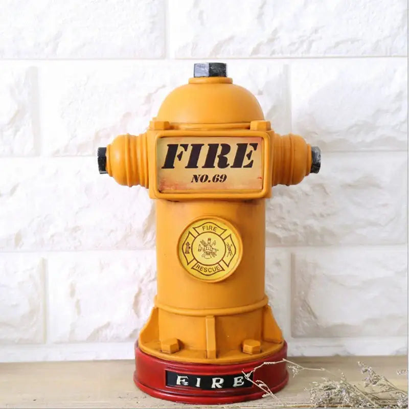 A vibrant yellow and red hydrant piggy bank with black caps and embossed fire branding for living room decor