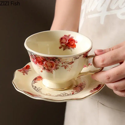 Cream-colored porcelain coffee mug and saucer set with delicate red rose patterns and golden edge for dining room use