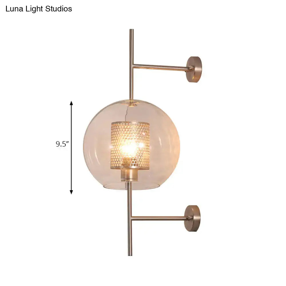 A vintage silver and gold clear glass sconce light with brushed brass finish and honeycomb glass globe for bedroom walls