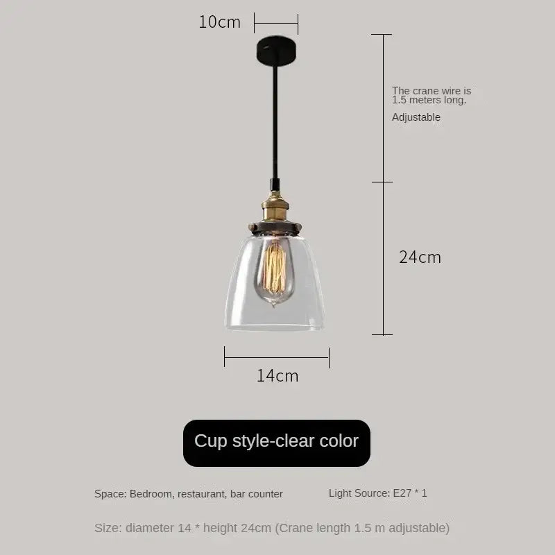 Clear glass cup-style pendant light with brass fixture and exposed edison bulb in vintage amber glass pendant light set