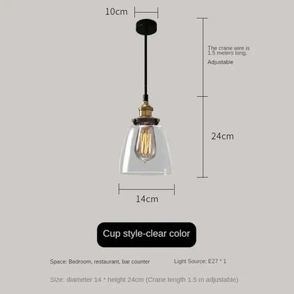 Clear glass cup-style pendant light with brass fixture and exposed edison bulb in vintage amber glass pendant light set