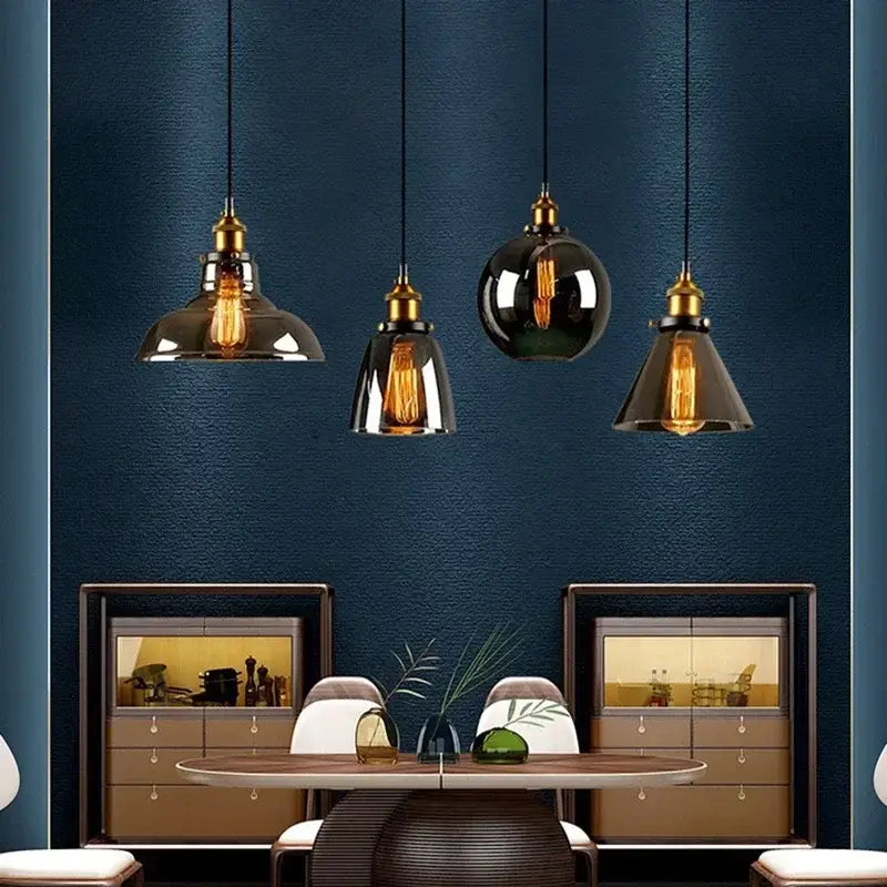 Four vintage pendant lights with brass fixtures and decorbites amber glass in smoked and glossy black finishes for dining room