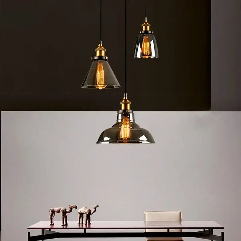 Three vintage-style pendant lights with brass fixtures and decorbites amber glass shades for dining room decor