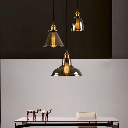 Three vintage-style pendant lights with brass fixtures and decorbites amber glass shades for dining room decor