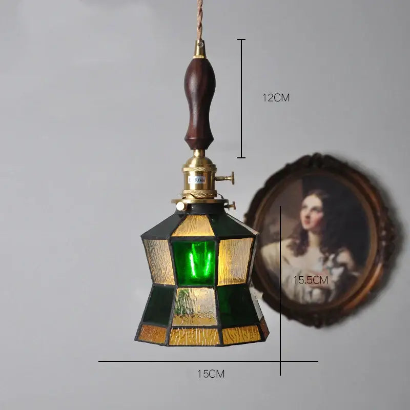 Vintage stained glass copper pendant light with green and amber panels, dark wood knob switch, and brass fittings for kitchen