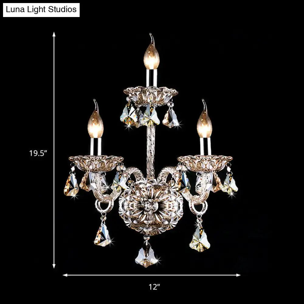A vintage style amber crystal candle wall light featuring a three-arm silver metal chandelier with faceted crystals