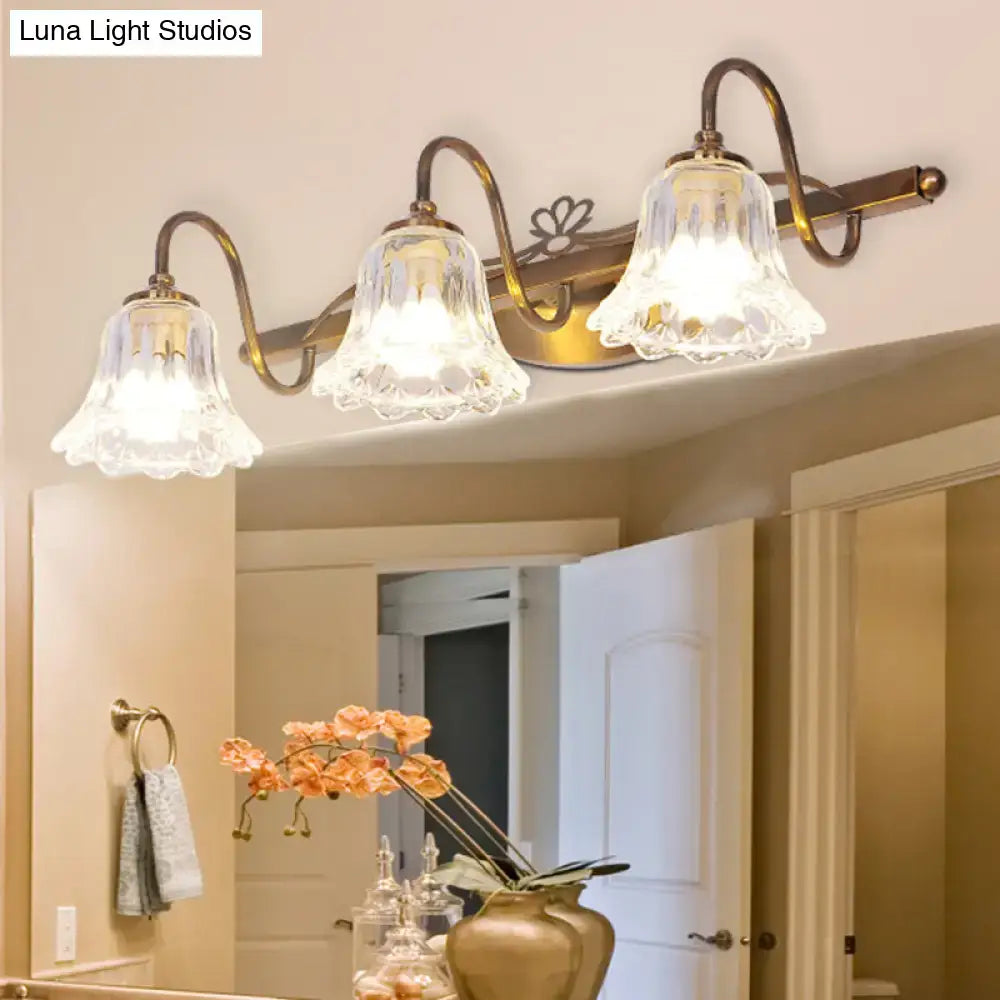 Antique brass vintage style wall light with three clear scalloped glass shades for bathroom vanity use