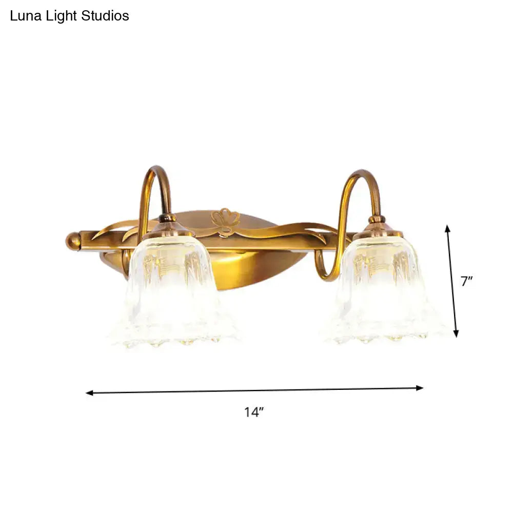 Vintage style antique brass two-light wall light with clear textured glass shades for bathroom vanity use