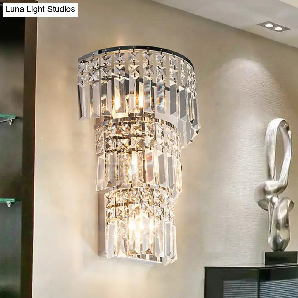 Vintage style clear crystal tiered wall sconce with cascading prisms and polished chrome frame for hallway lighting