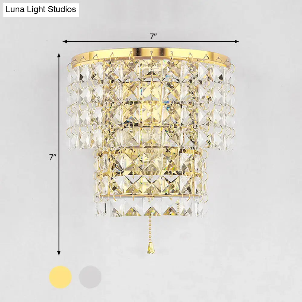 Vintage style wall sconce featuring gold-finished crystal with tiered clear faceted crystals and matching pull chain