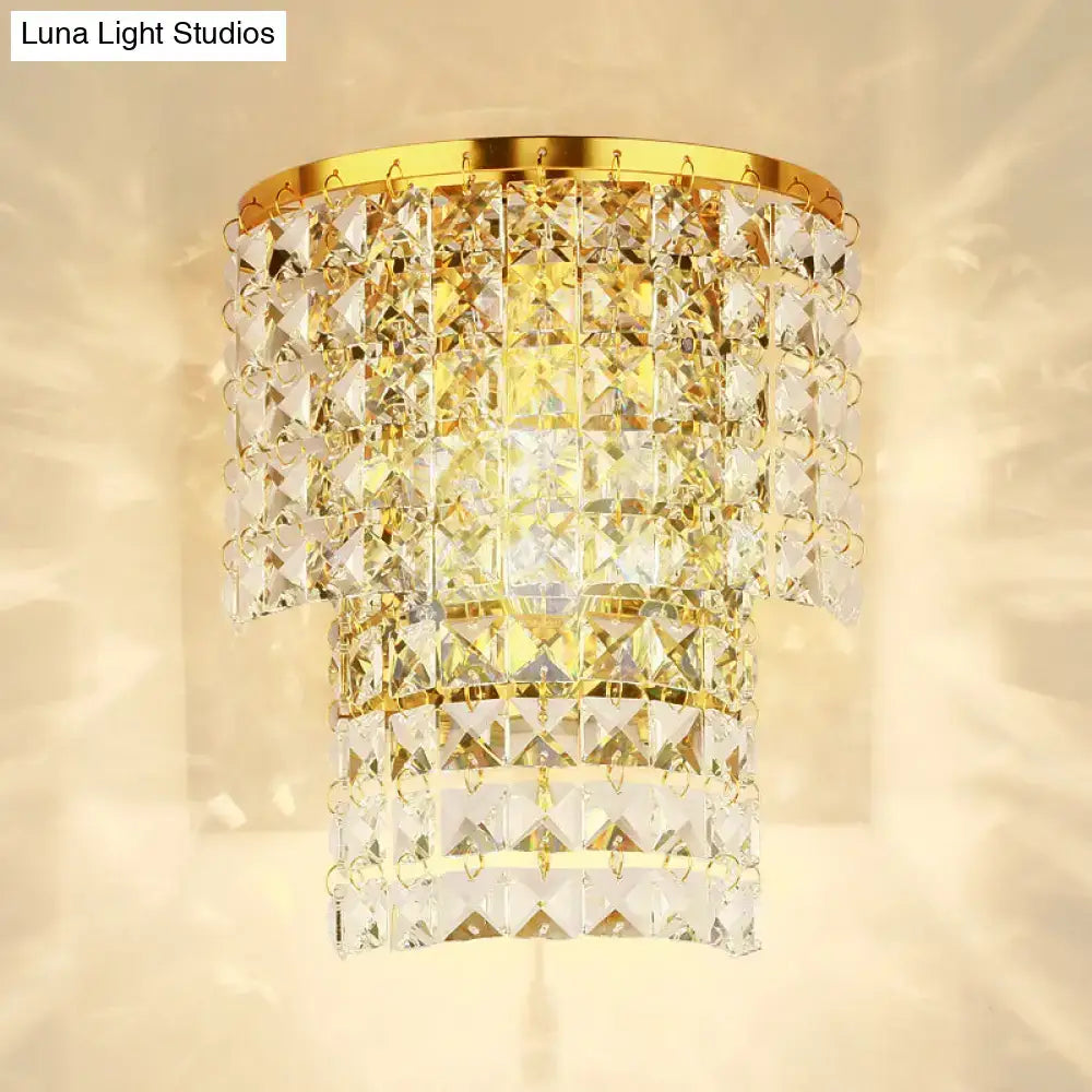 Vintage style wall sconce with gold-toned crystal chandelier featuring tiered faceted glass and polished brass frame