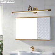 Vintage style gold metallic tubular wall light with a sleek elongated bar design and ornate decorative fixtures for bathroom vanity