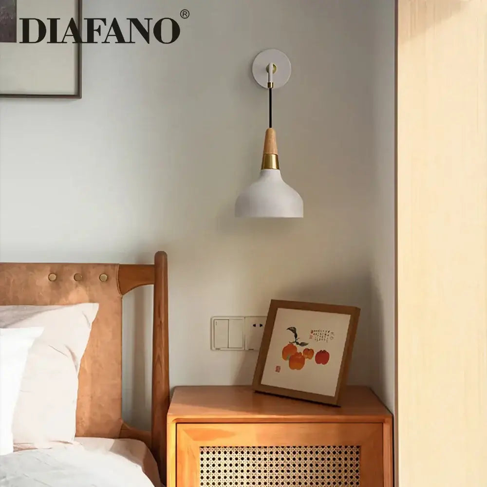 Vintage white ceramic wall lamp with wood accent and brass hardware mounted on the wall for bedroom lighting