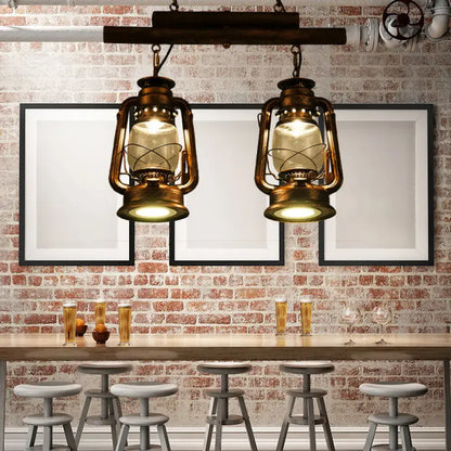 Two vintage-style brass lanterns with warm glow hang from wood beam in decorbites copper lantern island light fixture