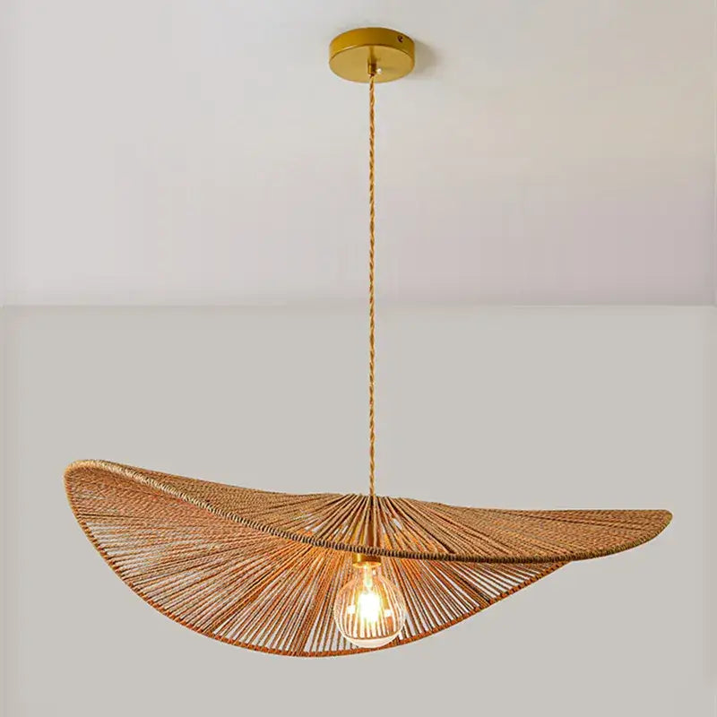 A warm-toned woven rattan bamboo wabi sabi pendant light with golden fixture for dining room illumination