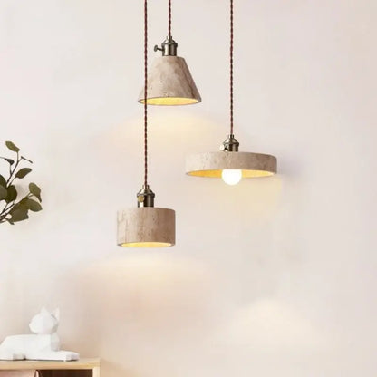 Three beige concrete pendant lights with warm led yellow travertine interiors and dark braided cords for dining room decorbites led yellow