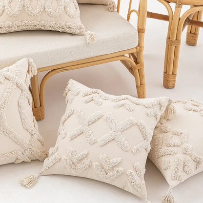 Cream-colored tufted cushion cover with textured geometric patterns and tassels for living room decor